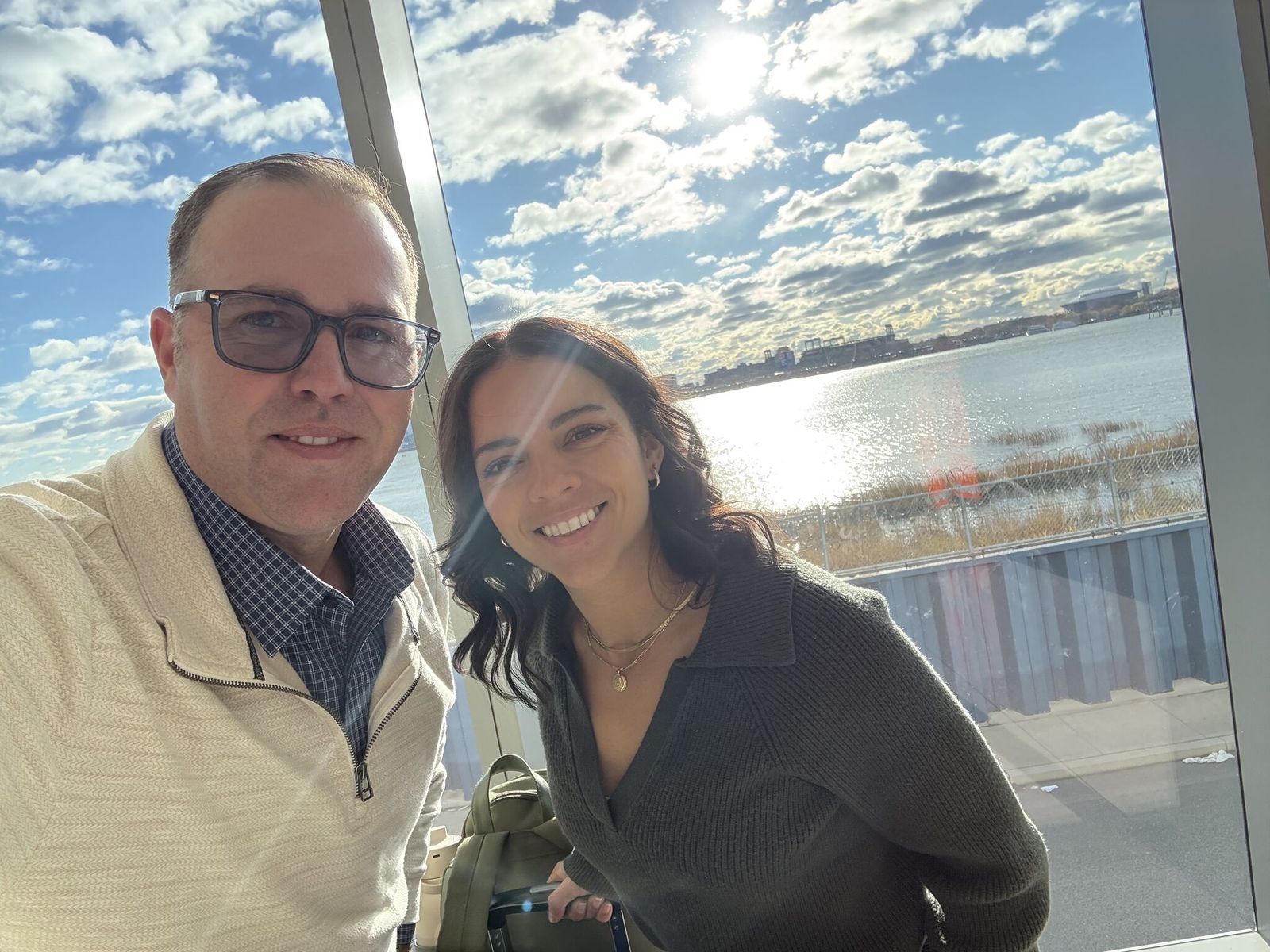 Two members of the Clover team in front of a sunlit waterfront window.